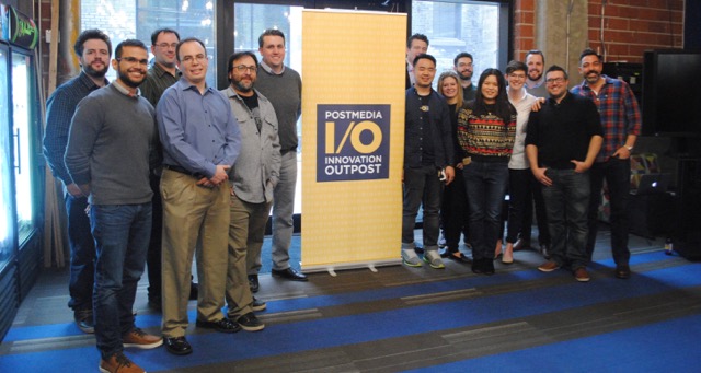 A large group of people pose together for a picture in an office space