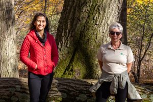 Two women standing for a photo on a forest trail