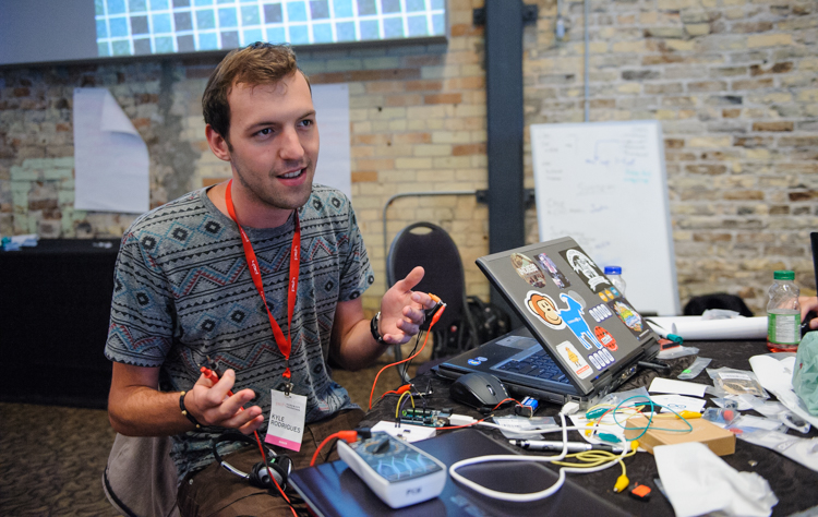 Participant explaining their idea around a cluttered table