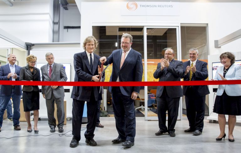 Thomson Reuters executives cutting a red ribbon