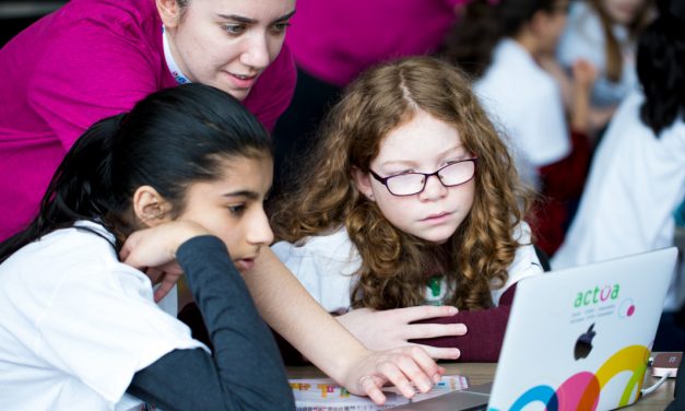 Mentor helping 2 student participants on a laptop