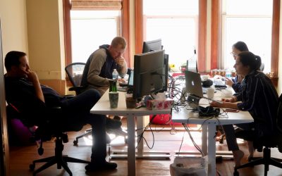 Four People working at their desks in the InFlight office