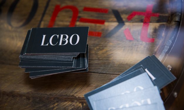 A pile of LCBO business cards on a wooden table