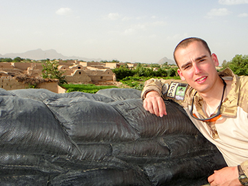 William Werth resting on sandbags in Afghanistan